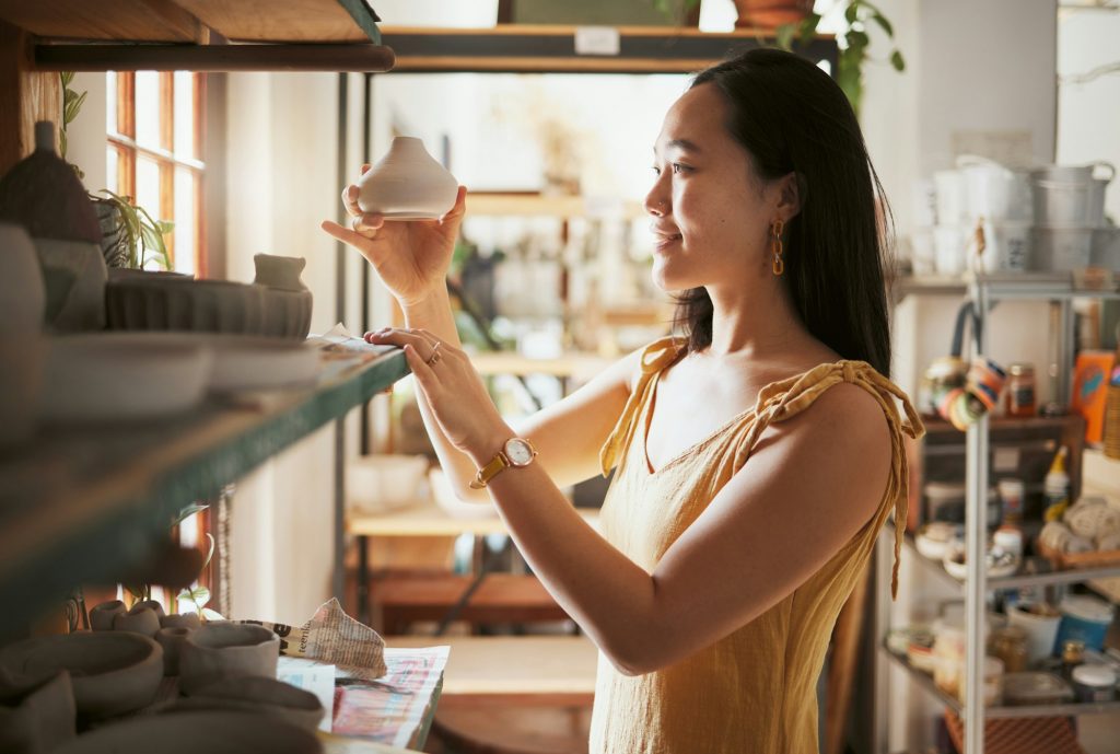 Pottery, small business and display with a woman entrepreneur working in a studio, selling products